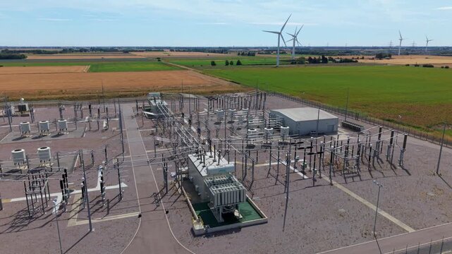 Aerial view of the Triton Knoll offshore windfarm 400220kV substation with electrical infrastructure and wind turbines in the background in Boston, England, United Kingdom.