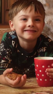 Vertical video. Child drinking milk with cookies at Christmas. Cozy festive mood