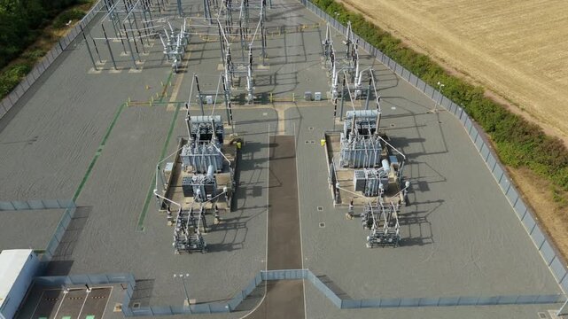 Aerial view of the National Grid Ryhall Substation 400kV featuring large air-cooled transformers, metal infrastructure, and security fencing in Ryhall, England, United Kingdom.