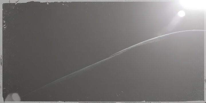 A blurry grayscale image with a curved line and bright light