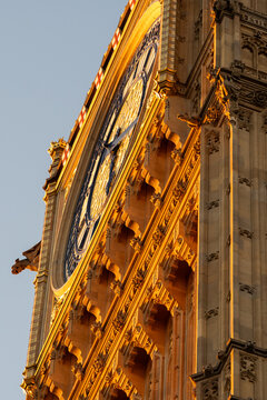 London, United Kingdom - 25 August 2025: View of the intricate clock face and gothic architecture of Big Ben illuminated by the warm golden light of the setting sun.