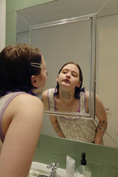 Young person looking at themselves in the mirror