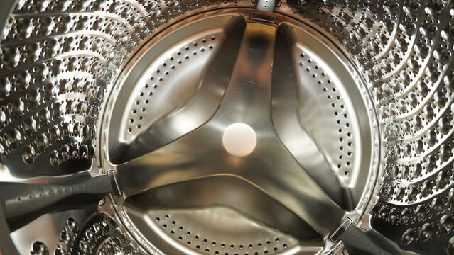 Close-up interior view of an empty, clean stainless steel washing machine drum