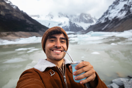 Man enjoying mate tea with a scenic mountain backdrop in Patagonia