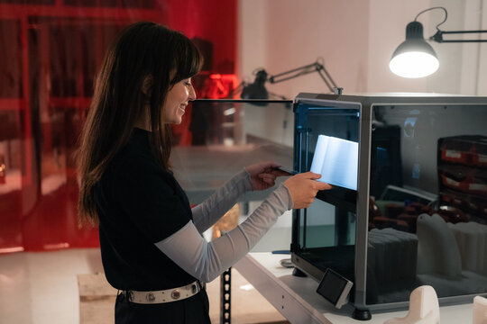 Smiling woman using 3d printer at design studio