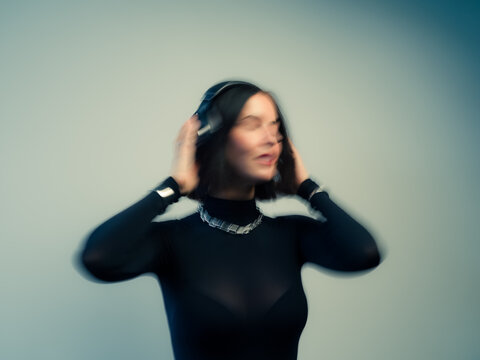 Woman dancing and listening to music in motion blur
