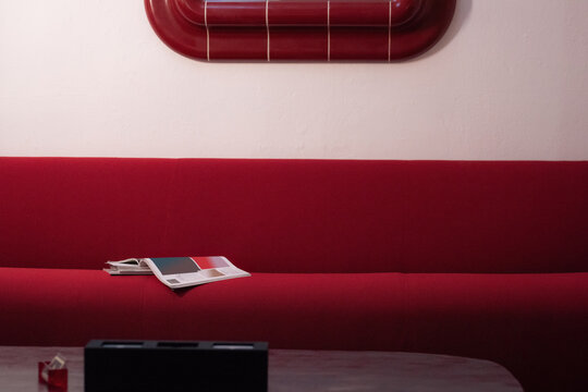 Red Sofa With a Magazine Placed on It in a Simple Room