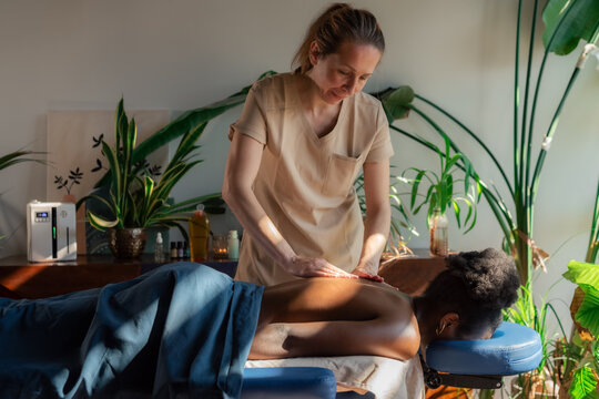 Woman Receives Massage in a Cozy Room With Plants