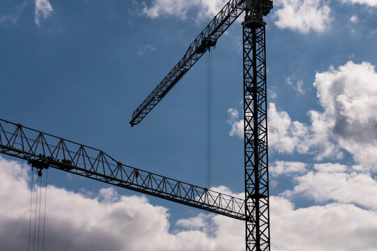 Tower Crane Jibs Against Sky