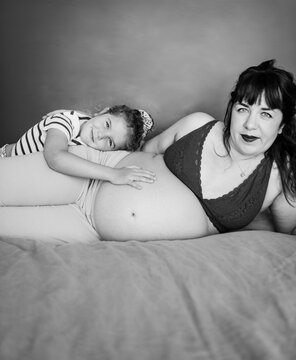 Artsy black and white portrait of pregnant mother and daughter
