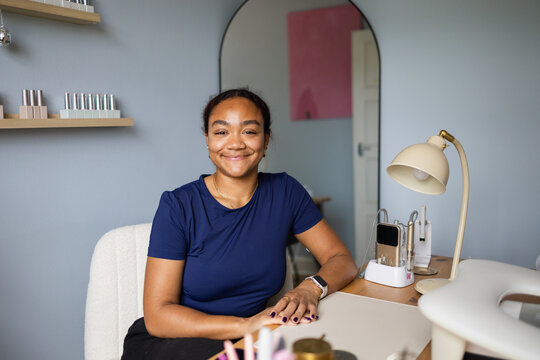 Nail artist posing at her beauty salon workstation