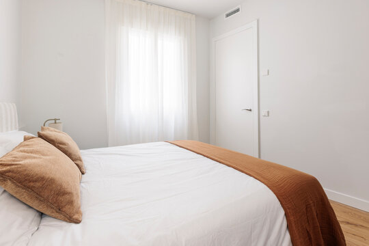 Bed detail with terracotta throw