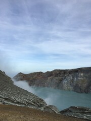 Volcanic crater lake with steaming sulfur vents and rocky mountain landscape scenery. © Design_Vr