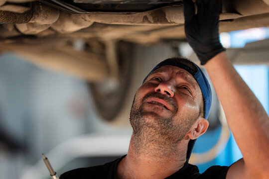 Mechanic Inspecting Car Underside