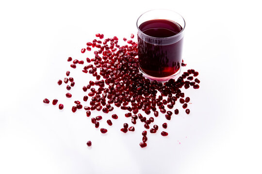 Pomegranate juice in glass isolated on white. Pomegranate arils and halves. Healthy antioxidant drink. Pomegranate juice and seeds. Pomegranate juice drink.