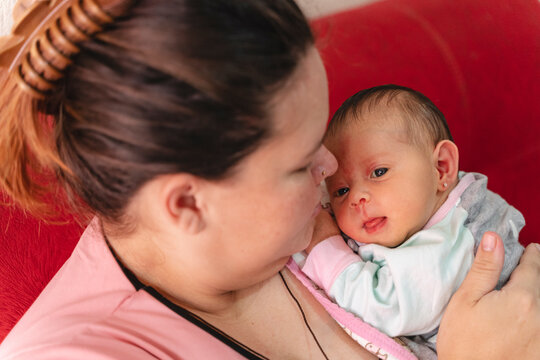 Mother holding newborn infant embracing maternal love