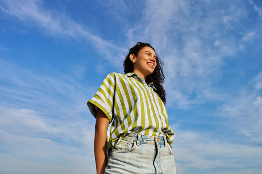 Happy woman smiling looking away under blue sky
