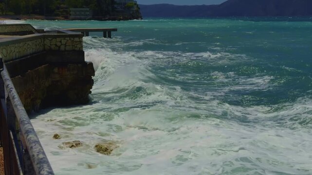 Powerful Waves Crashing Against Stone Embankment Wall Splashing Foam.Stormy Sea Water. Marine Environment 