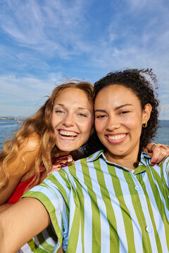 Diverse women friends smiling taking selfie outdoors
