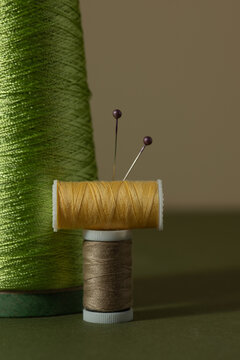 Sewing Spools and Pins against a muted background
