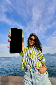 Woman presenting smartphone screen mockup for travel app