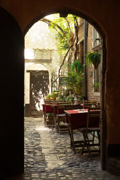 Beautiful cafe seating in historic courtyard, shot through an archway