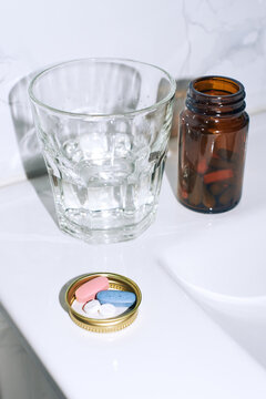 Setting a medicine bottle and pills near a sink
