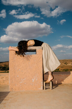 Relaxing Rooftop Pose Against Blue Sky Clouds