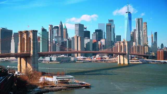 Brooklyn Bridge and Empire Stores overlooking East River. A small boat crosses the harbor as skyscrapers and a carousel pavilion line the shore.