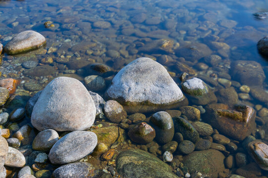Murti river in the morning, riverbed in foreground with flowing water and stones. Scenic beauty of Dooars landscape, West Bengal, India