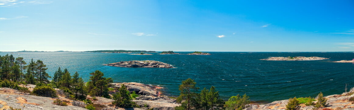 Kirkkonummi, Finland - 03.06.2018: Panoramic view of rocky archipelago with pine trees and choppy blue sea under a clear summer sky