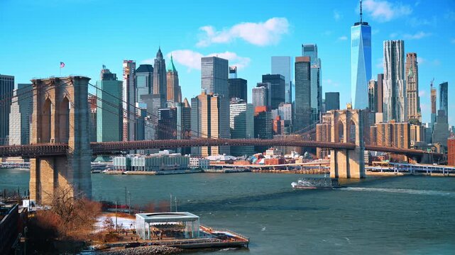 Brooklyn Bridge and Empire Stores overlooking East River. A small boat crosses the harbor as skyscrapers and a carousel pavilion line the shore.