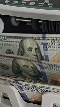 Money being processed in a counting machine at a bank in the morning
