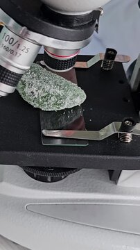 Researcher studies different types of candy on a table while taking notes and using a microscope in a laboratory