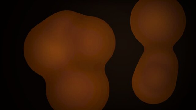 Glowing amber amorphous organic shapes floating in a deep black background