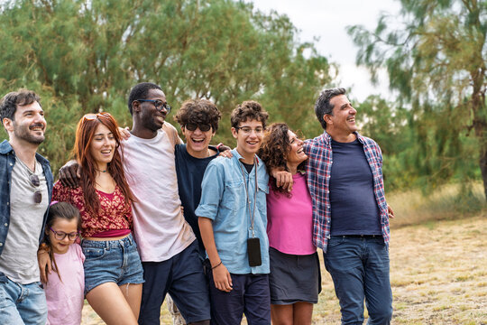 Multiethnic family and friends walking together outdoors smiling in nature