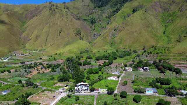 Aerial view of the lush green hills and rural village houses near Lake Toba in Paropo, Sumatera Utara, Indonesia.