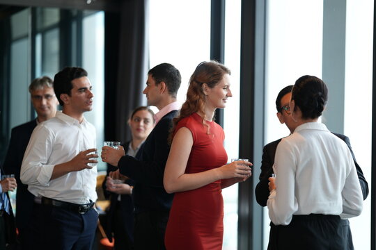 Business people at a rooftop reception, enjoying conversation at the hotel party at a bright hotel reception by the windows, capturing an upscale travel and lifestyle mood.