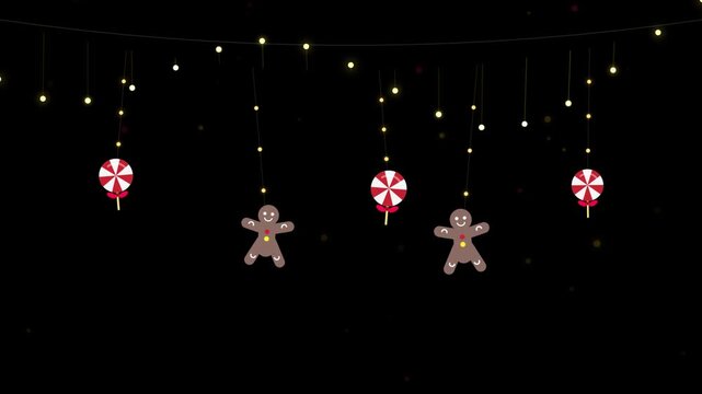 Hanging gingerbread men and candy lollipops on glowing string light garland for holiday background.