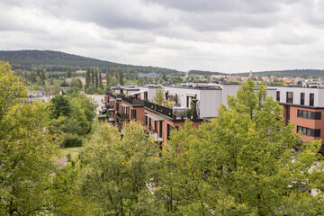 Widok na Góry Świętokrzyskie ponad miejską zabudową, zielone drzewa, wzgórza i współczesna architektura w pochmurny dzień. © Henryk Guziak