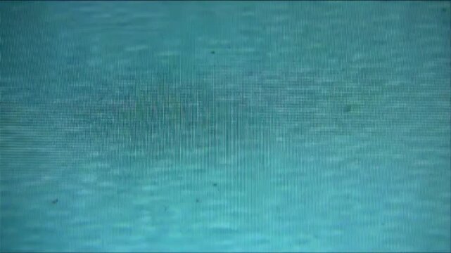 Flickering blue monitor screen filmed with vintage MiniDV camera, scan lines