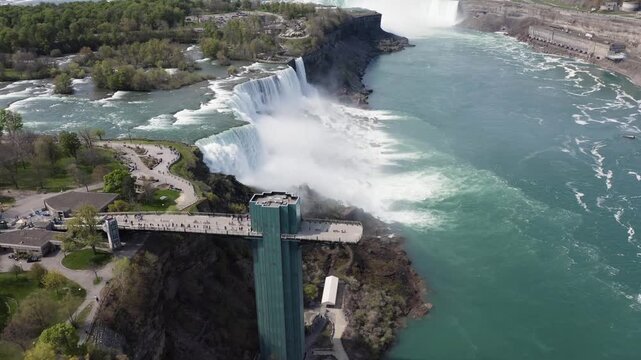 Aerial view of the powerful Niagara Falls with mist rising from the cascading water and surrounding parkland in Niagara Falls, Ontario, Canada.
