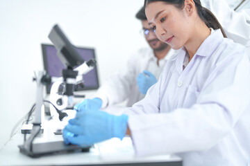 A diverse group of scientists discuss research results as a group in a bright modern laboratory...