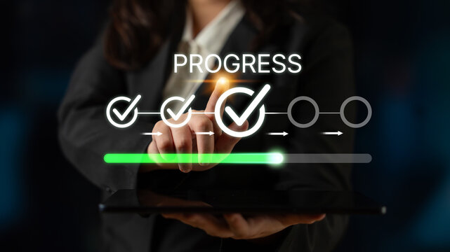 Business professional indicating progress and completion through digital interface with checkmarks and loading bar concept in modern office environment. Bitwise.