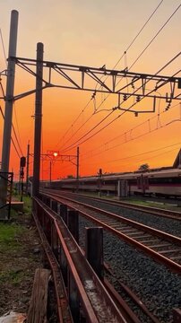 Two passenger trains passing each other on a railway track during a beautiful sunset, creating a scenic transportation