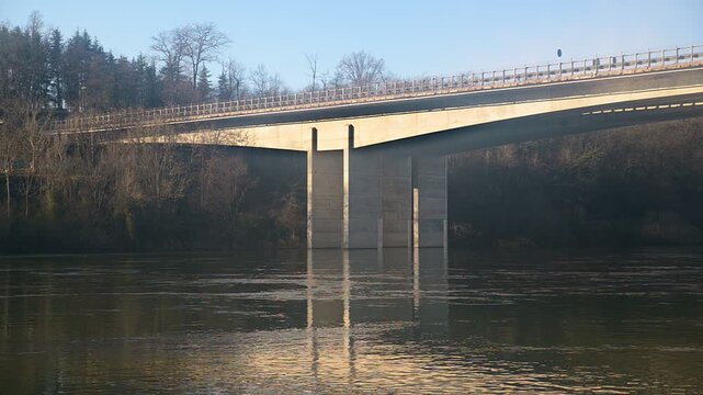 Ticino River motorway bridge in northern Italy near Sesto Calende, A8 A26 highway infrastructure over calm water under blue sky, static scenic low angle view