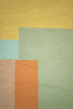 Abstract geometric color blocking on textured plaster wall