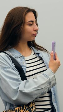 Caucasian woman taking phone selfie and checking look, striped top and denim jacket, leopard bag sling, playful confident expression, handheld smartphone capture, lifestyle mirror moment