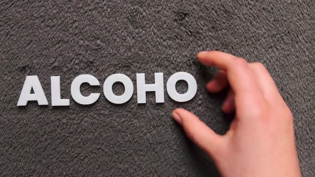 The word acoholism written on a dark background with white uppercase block letters (fast version)