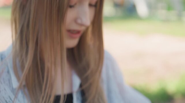 Close up of young woman organizing colorful yarn into her brown bag with gold hexagonal details. scene shows texture and pattern of lace fabric on clothing soft lighting in outdoor setting